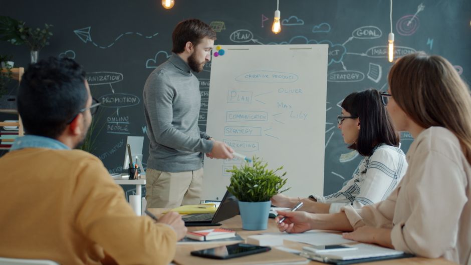 Equipo en una oficina moderna discutiendo la estrategia de un proyecto creativo