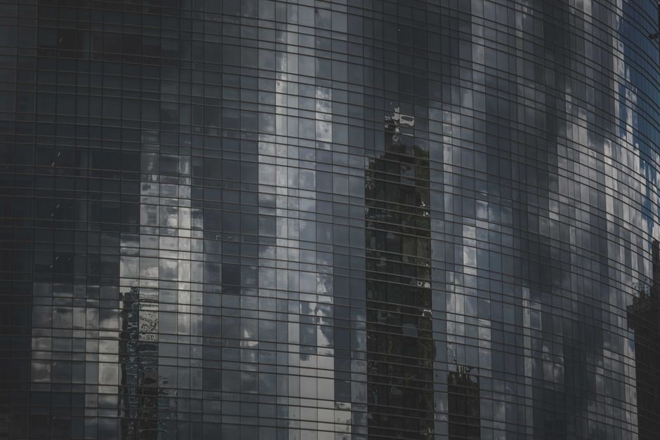 Edificio de cristal reflejando el horizonte urbano