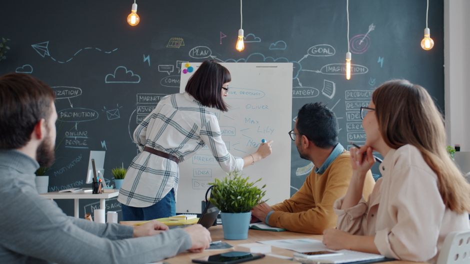 Grupo de colegas colaborando en un proyecto en una sala de reuniones creativa