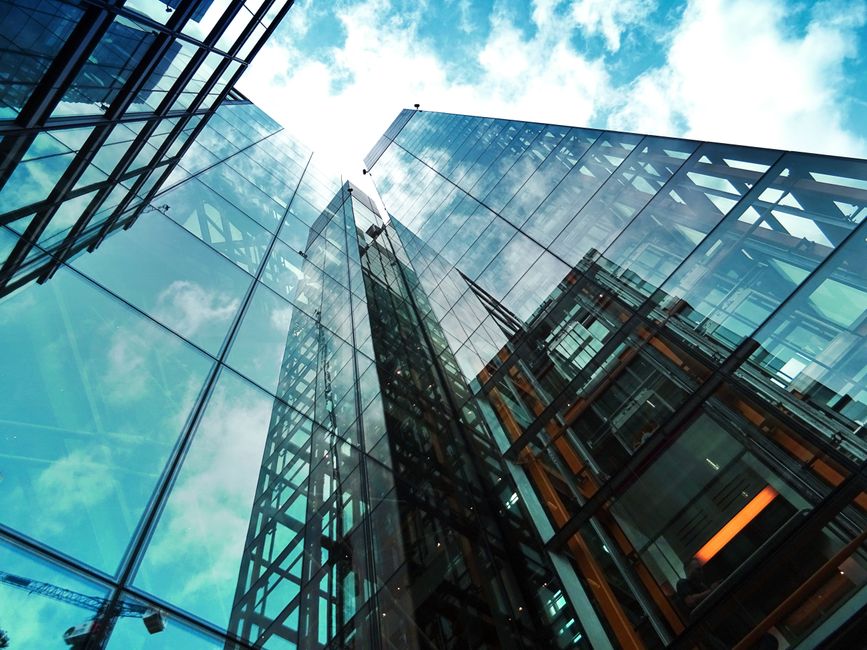 Vista de un moderno edificio de cristal reflejando el cielo y las nubes